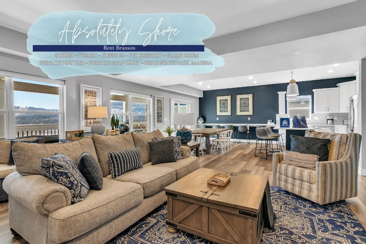 An inviting open-concept space featuring a comfortable sectional sofa, adjacent dining area, large windows capturing beautiful views, and a kitchen island in the background. The arrangement encourages relaxation, conversation, and shared activities within one connected area.
